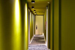 a hallway with green walls and a hallway with yellow ceilings at My Story Hotel Augusta in Lisbon