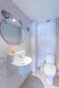uma casa de banho com um lavatório, um WC e um espelho. em Apartment Elena em L'Escala