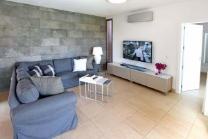 sala de estar con sofá azul y TV en Salobre Par 4 Nº4, en Maspalomas
