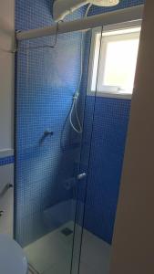 Casa Perequê 100 metros da praia في إلهابيلا: حمام مع دش وباب زجاجي