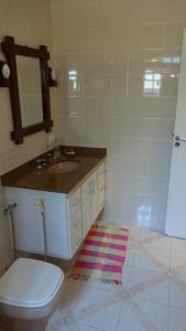Casa Perequê 100 metros da praia في إلهابيلا: حمام مع حوض ومرحاض ومرآة