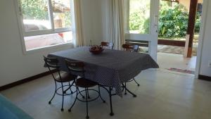 Casa Perequê 100 metros da praia في إلهابيلا: طاولة طعام مع كراسي وطاولة مربعة باللونين الأبيض والأسود +16 صورة