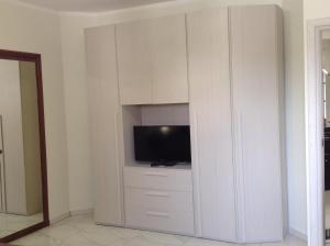 une grande armoire blanche avec une télévision. dans l'établissement La stanza di villa Sara, à Civitavecchia