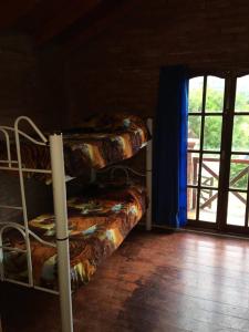 two bunk beds in a room with a window at Cabañas Rosarito in Villa Larca