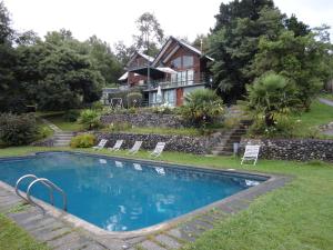 una casa con piscina frente a una casa en Complejo Turístico Pucón, en Pucón