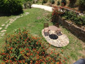 un patio con 2 sillas, una mesa y flores en Casa vacanze Il Mandorlo, en Perdifumo