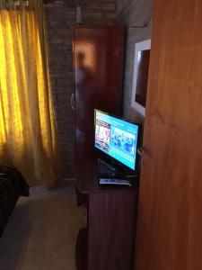 Habitación con ordenador, escritorio y TV. en Cabañas Rosarito en Villa Larca