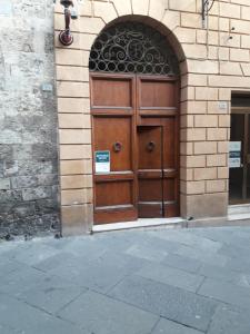 duże drewniane drzwi na boku budynku w obiekcie Luxury Suite apartment Angiolieri w Sienie