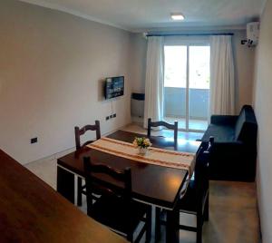 ein Wohnzimmer mit einem Tisch und einem Sofa in der Unterkunft Departamento - Edificio Costanera in San Salvador de Jujuy