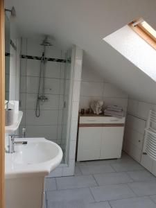 ゾントホーフェンにあるFerienwohnung Litauの白いバスルーム(シンク、シャワー付)