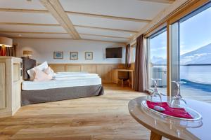 ein Hotelzimmer mit einem Bett und einem Tisch in der Unterkunft Granpanorama Hotel StephansHof in Villanders