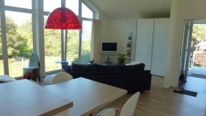 a living room with a black couch and a red lamp at Fewo Ausblick in Hechthausen