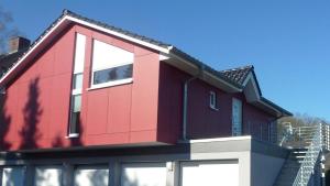 ein rotes Haus mit einem Gameradach in der Unterkunft Fewo Ausblick in Hechthausen