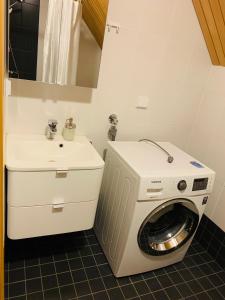 een badkamer met een wasmachine en een wastafel bij Rauha Marina 5 in Imatra