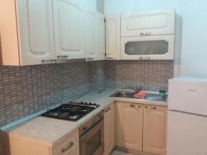 cocina con armarios blancos y fogones en Vlora Apartment, en Vlorë