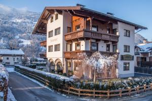 a building in the mountains with snow on the ground at Birkenhof in Zell am Ziller