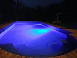una piscina iluminada de azul por la noche en Al lado en Córdoba