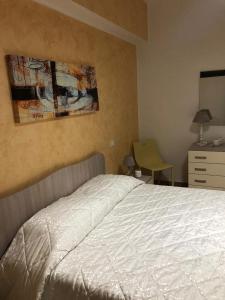1 dormitorio con cama blanca y vestidor en House Le Fontanelle en Lizzano