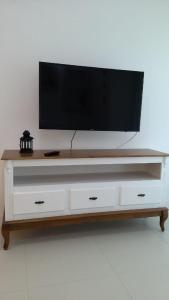 a flat screen tv on top of a white entertainment center at Apartamento Espelho das Águas in Florianópolis