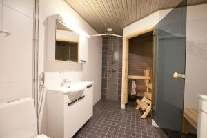 un baño con lavabo y ducha en Kansankatu Apartments, en Rovaniemi 9 fotos más