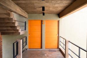 two wooden doors in a hallway with stairs at VIÑA alquileres temporarios in San Salvador de Jujuy