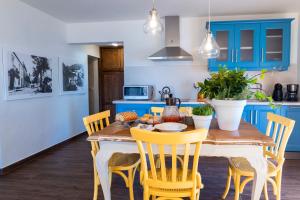 a kitchen with a wooden table and yellow chairs at Casa Azul in Fuencaliente de la Palma