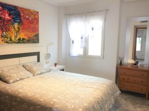 トレビエハにあるSeafront Dream Apartmentのベッドルーム1室(ベッド1台付)が備わります。壁には絵画が飾られています。