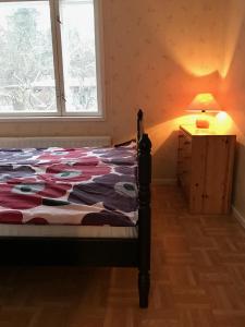 um quarto com uma cama, um candeeiro e uma janela em Idyllinen kaksio em Kankaanpää