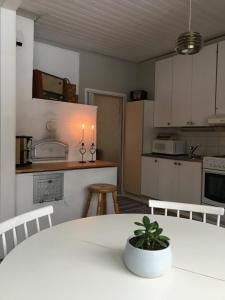 a kitchen with a white table with a potted plant at Idyllinen kaksio in Kankaanpää