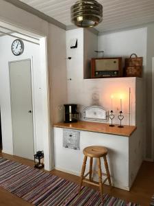 a kitchen with a counter and a stool and a clock at Idyllinen kaksio in Kankaanpää +16 photos