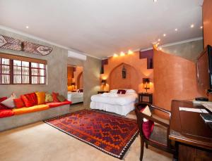 a large bedroom with a bed and a couch at Singa Lodge - Lion Roars Hotels & Lodges in Port Elizabeth