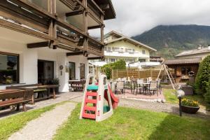 einen Hinterhof mit einem Spielplatz mit Rutsche in der Unterkunft Hotel Tirolerhof in Bruneck