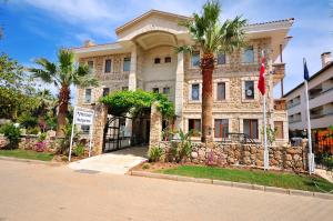 a building with palm trees in front of a street at My Marina Select Hotel in Datca