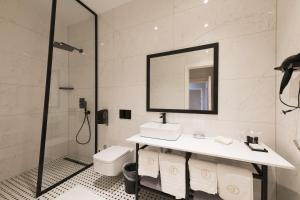 a bathroom with a shower, sink and mirror at Boutique hotel Tvrđa in Osijek