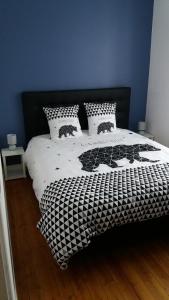 a bedroom with a black and white bed with pillows at Appartement Taïko in La Flèche