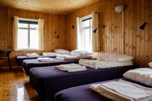 a row of beds in a room with wooden walls at Ósar Hostel in Tjörn