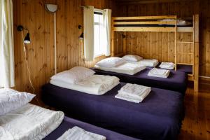 a room with three beds and a bunk bed at Ósar Hostel in Tjörn