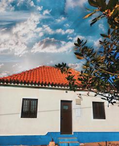 シーネスにあるMonte da Amorosaのオレンジ色の瓦屋根の白い家