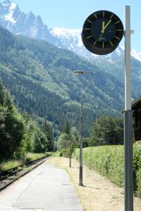 a clock on a pole next to a street light at Eden Hotel, Apartments and Chalet Chamonix Les Praz in Chamonix-Mont-Blanc