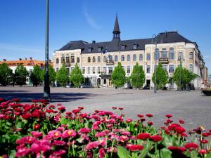 un gran edificio con flores rojas delante de él en Varbergs Stadshotell & Asia Spa, en Varberg