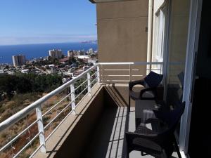 balcón con 2 sillas y vistas al océano en Horizonte Infinito Viña del Mar, en Viña del Mar
