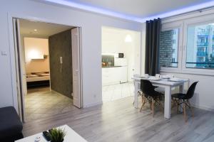a dining room and living room with a table and chairs at APARTAMENT FOCUS in Gdynia