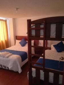 1 dormitorio con 2 literas y escalera en Hostal Alborada Riobamba en Riobamba