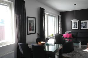 a living room with a glass table and chairs at Joutsen Apartments in Rovaniemi