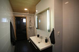 a bathroom with a sink and a mirror at Joutsen Apartments in Rovaniemi