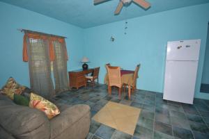 a living room with a couch and a white refrigerator at Lamblion Holiday Apartment in Freemans