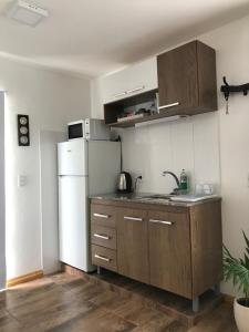 a kitchen with a white refrigerator and wooden cabinets at Grand Hotel Mariscala in Mariscala +34 photos