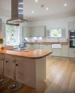 a kitchen with white cabinets and a wooden counter top at The Gardener's Cottage in Dunblane