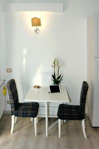 ミラノにあるSan Luigi Milano Apartmentの白いデスク(椅子2脚、ノートパソコン付)
