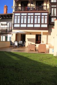 een huis met stoelen en een balkon met een patio bij Casa Santiago in Comillas